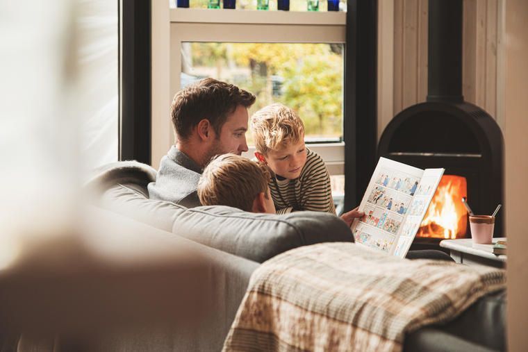 Familie im Ferienhaus am Kamin